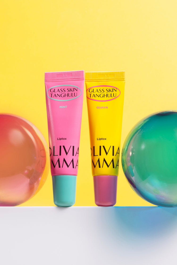 Two lip balms with colorful Christmas ornaments on a yellow background