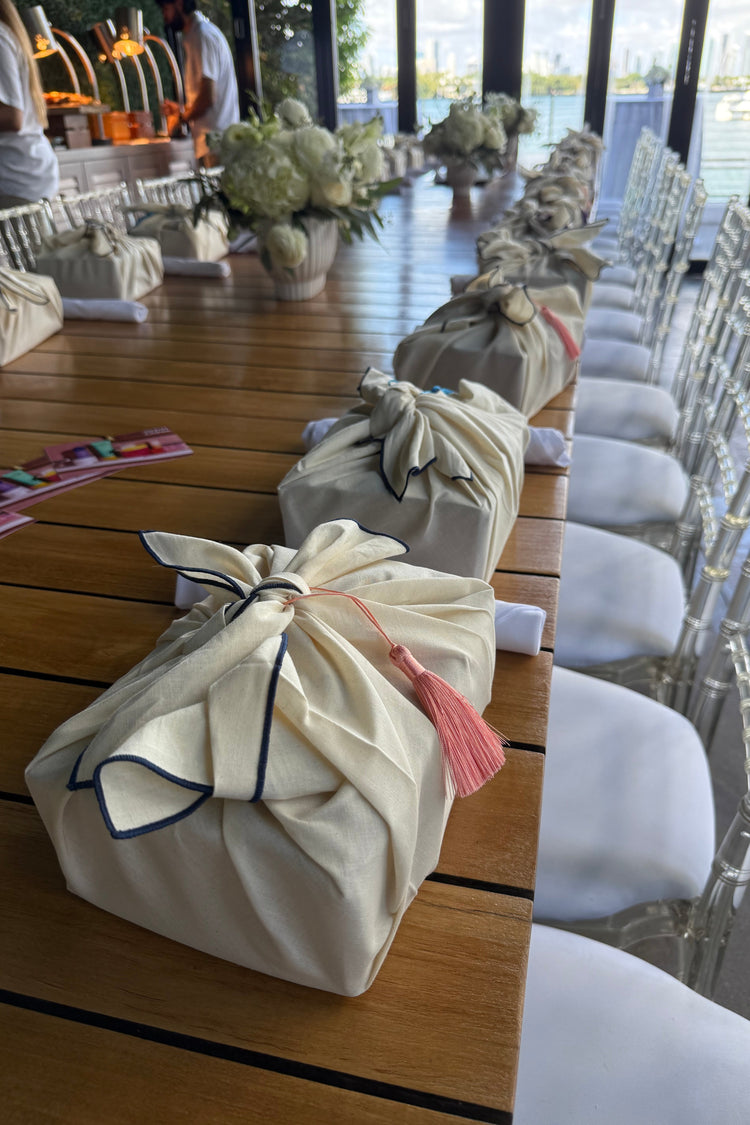 White chairs with covers on a wooden bench against a cityscape background