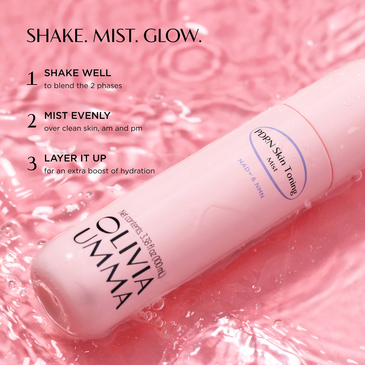 PDRN Skin Toning Mist labeled OLIVIA UMMA and placed on a pink liquid surface with water droplets. Text at the top reads 'SHAKE. MIST. GLOW.'