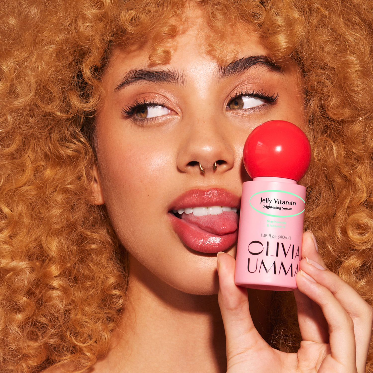 Woman holding a Oliva Umma skincare product with a close-up of the product.