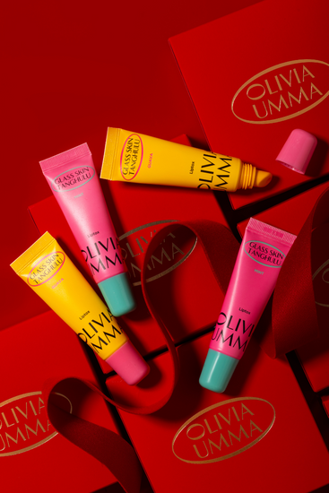 Collection of Olivia Umma lip products on a red background