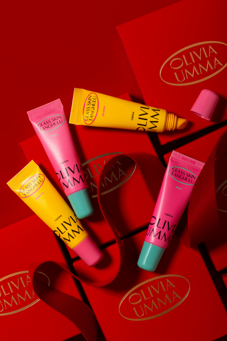 Collection of Olivia Umma lip products on a red background