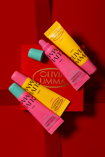 Colorful lip glosses with 'Oliva umma' branding on a red background