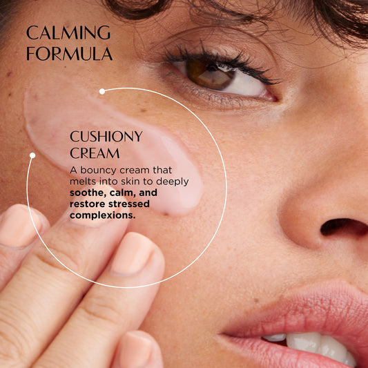 Close-up of a person applying cushiony cream to their skin with text about the calming formula.