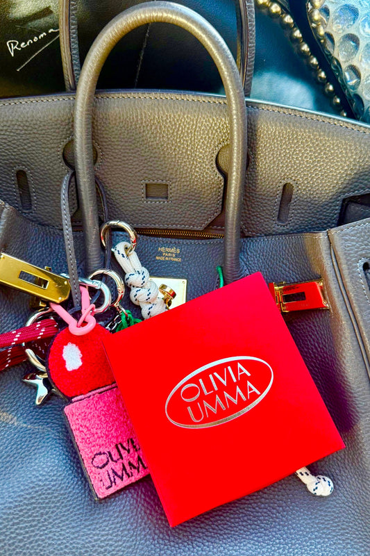 Olivia Umma keychain and pouch on a textured surface