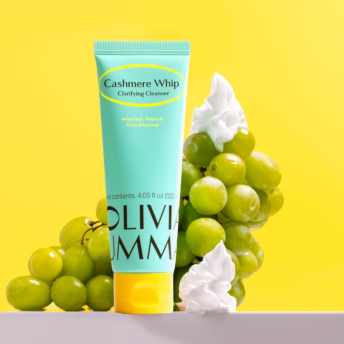 Olivium Cashmere Whip Cleanser with grapes on a yellow background