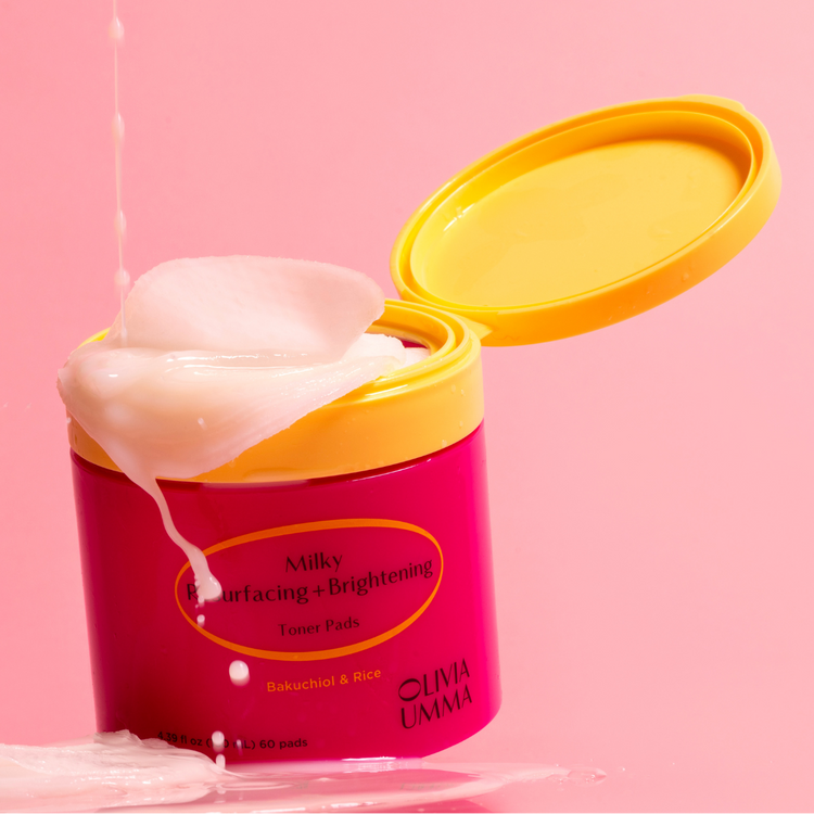 Milky Resurfacing + Brightening Toner Pads
with yellow lid on a pink background, featuring the brand 'Olivia Umma'.