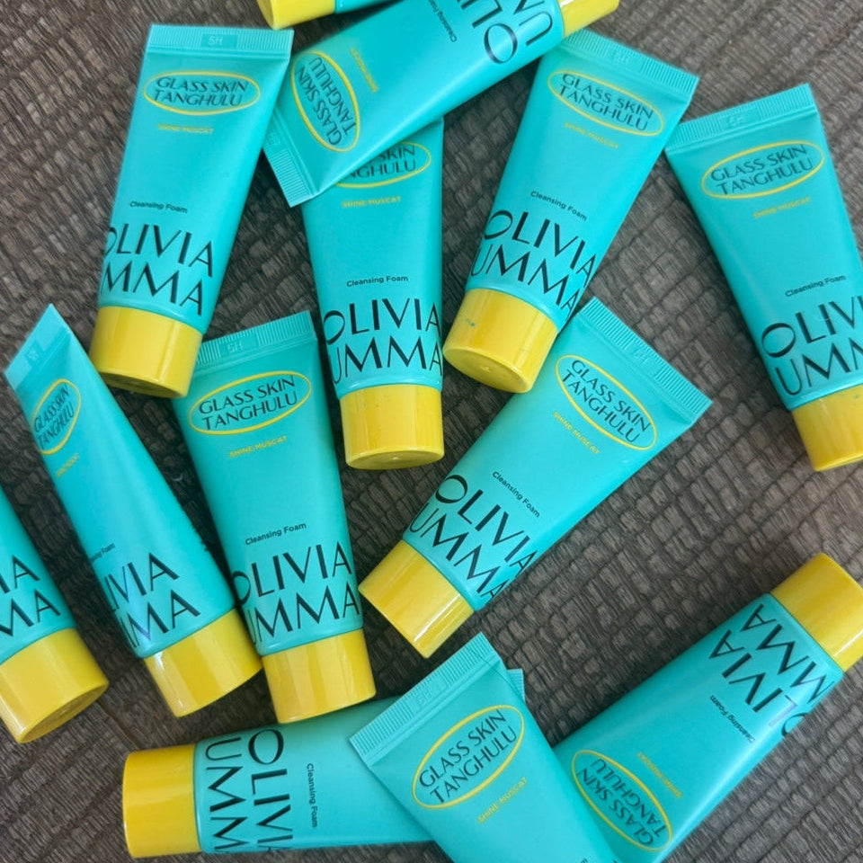 Multiple tubes of Olivia Emma skincare product on a textured surface