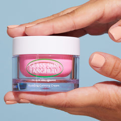 Hand holding a jar of Glass Skin Tanghulu pudding calming cream against a blue background